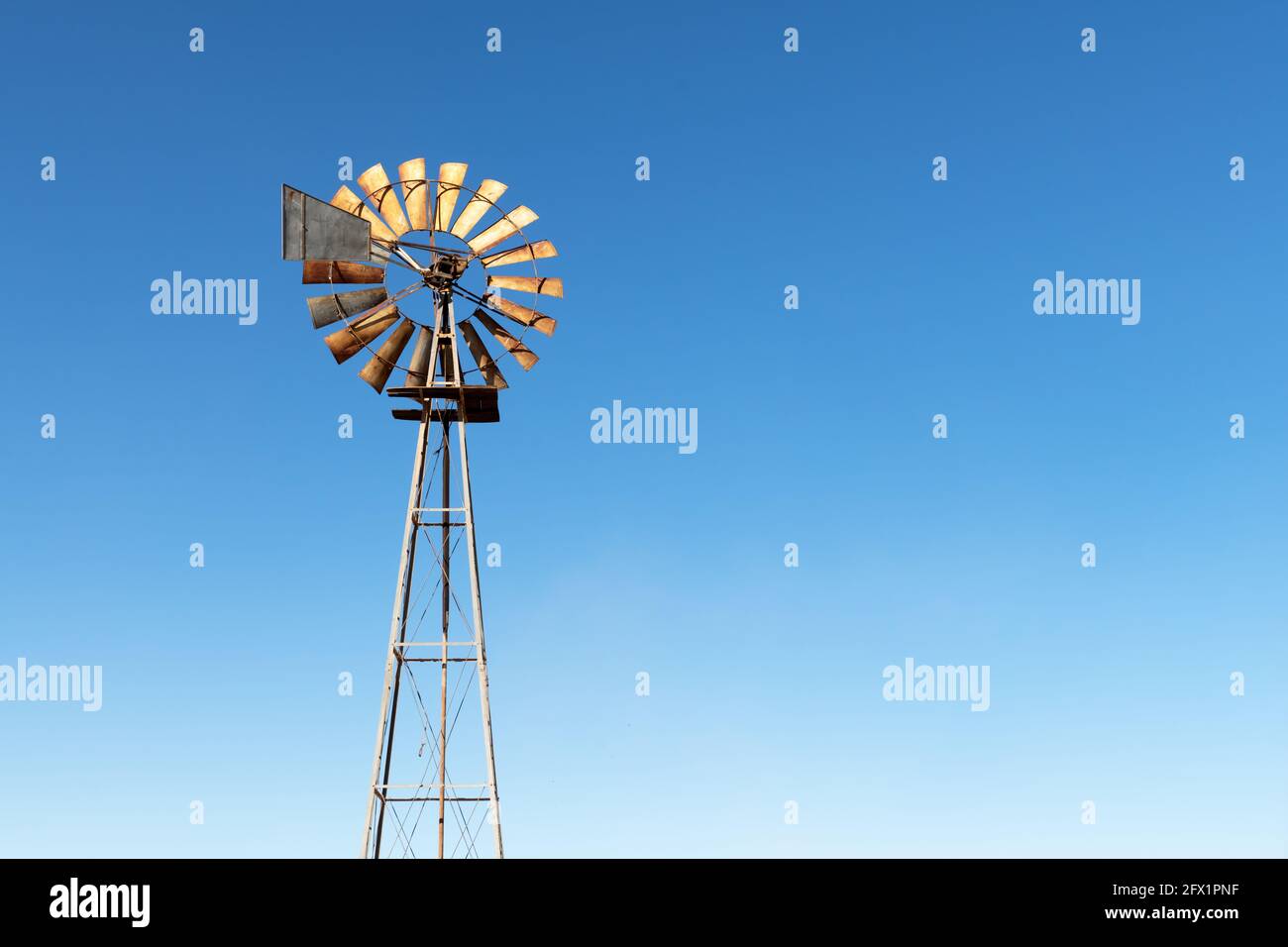 Alte rostige Windturbine vor blauem Himmel Stockfoto