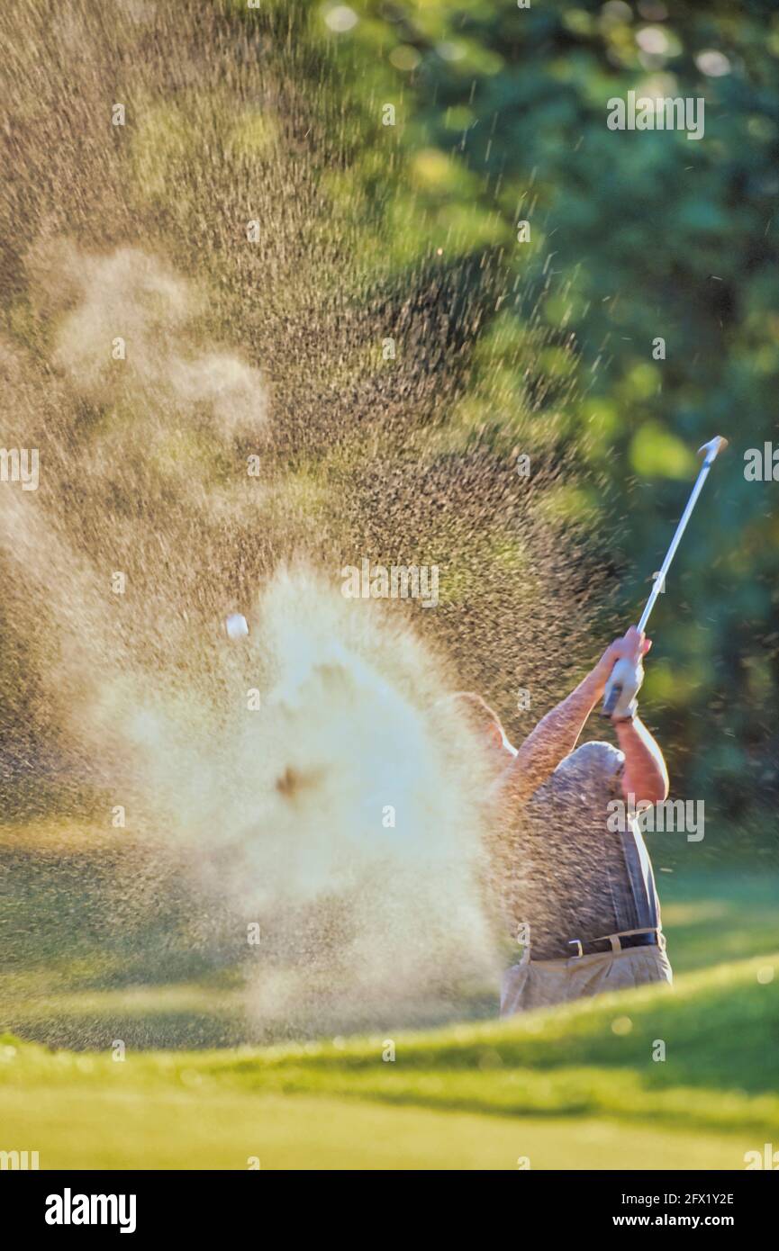 Mann spielt Golfball aus Bunker, Wimbledon, London, Großbritannien. )Model Release im Besitz des Fotografen) Stockfoto