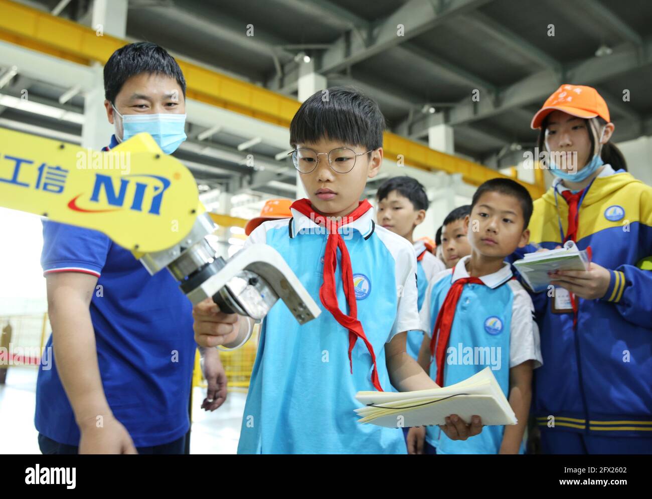 Cangzhou, Chinas Provinz Hebei. Mai 2021. Studenten der Linhai Road Primary School erleben Industrierobotertechnologien im Cangzhou Laser Industry Park in Cangzhou, nordchinesische Provinz Hebei, 25. Mai 2021. Während der National Science and Technology Week besuchten Studenten der Linhai Road Primary School den Cangzhou Laser Insdustry Park, um Lasertechnologien kennenzulernen und sich über Industrieroboter zu informieren. Quelle: Luo Xuefeng/Xinhua/Alamy Live News Stockfoto