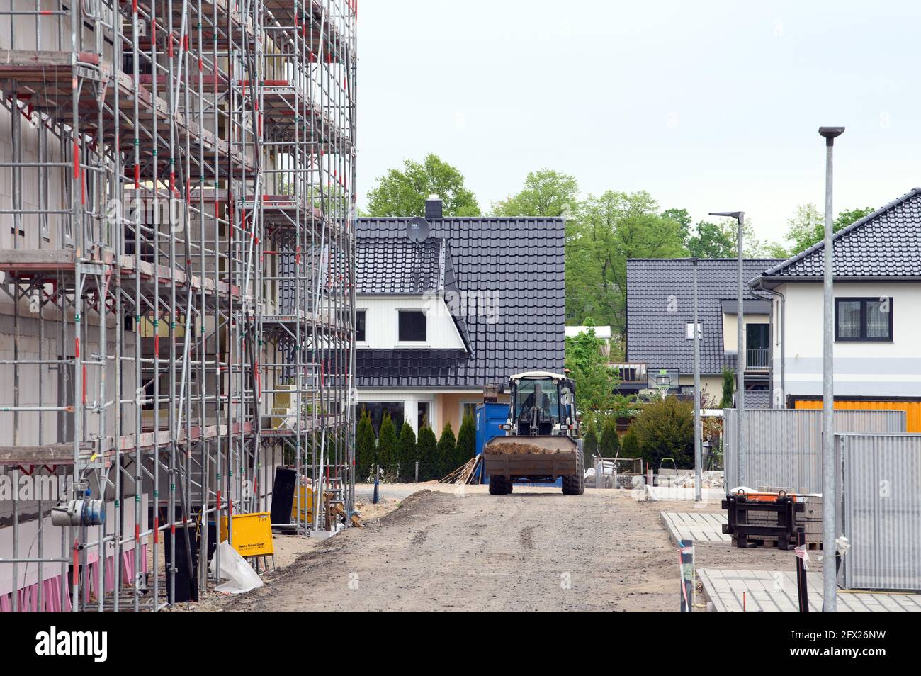 Oranienburg, Deutschland. Mai 2021. Die neuen mehrstöckigen Gebäude der Oranienburger Wohnungsbaugesellschaft (WOBA) in der Weißen Stadt an der Emil-Büge-Straße/Ecke Walther-Bothe-Straße befinden sich im Rohbau. Im Hintergrund sind die Einfamilienhäuser der Johannes-Rau-Straße zu sehen. Quelle: Soeren Stache/dpa-zentralbild/dpa/Alamy Live News Stockfoto