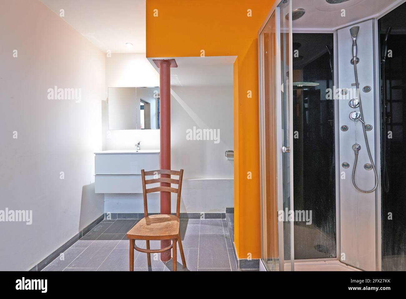 Bad und Dusche im Loft mit oranger Wand Stockfoto
