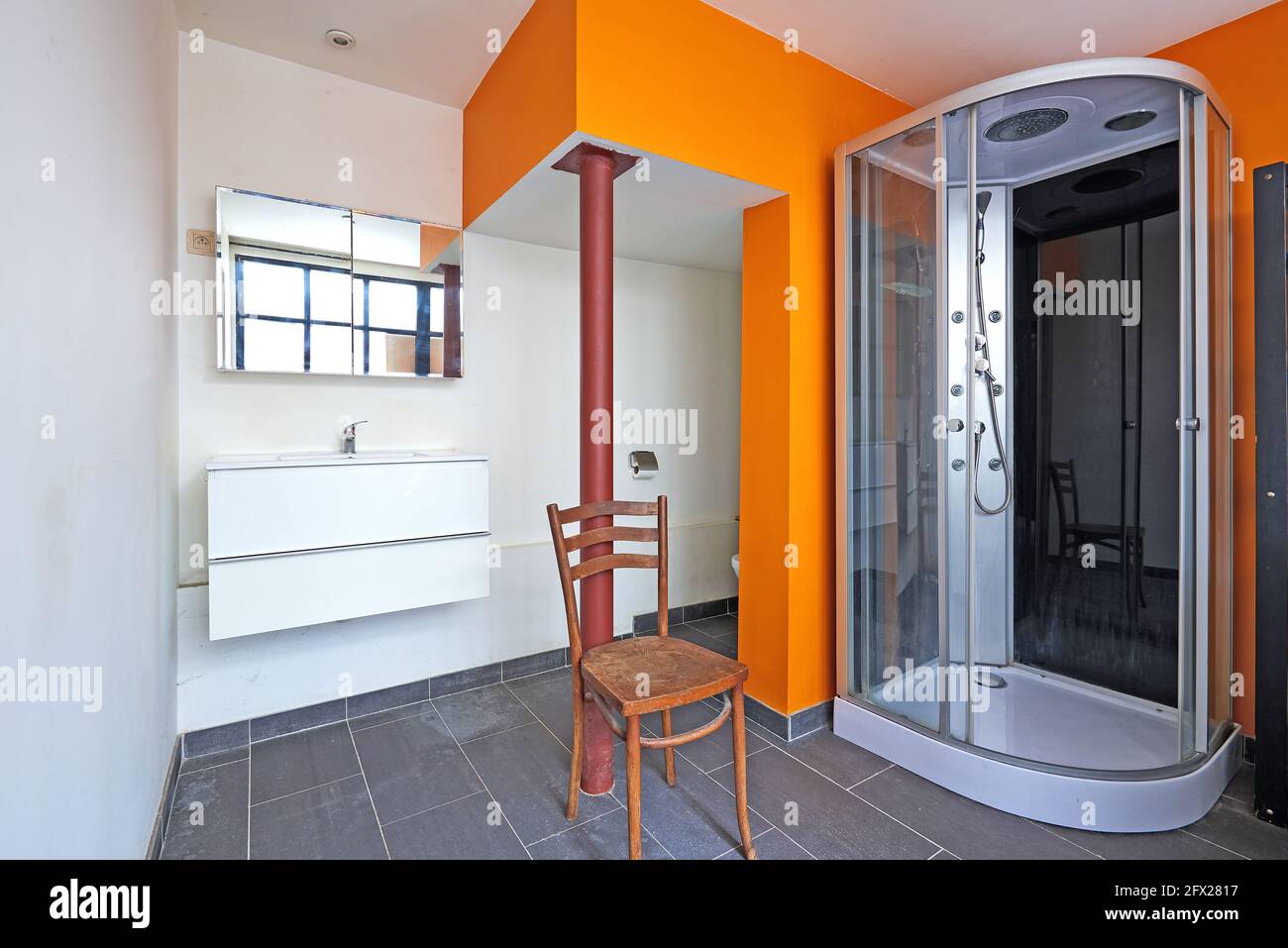 Bad und Dusche im Loft mit oranger Wand Stockfoto