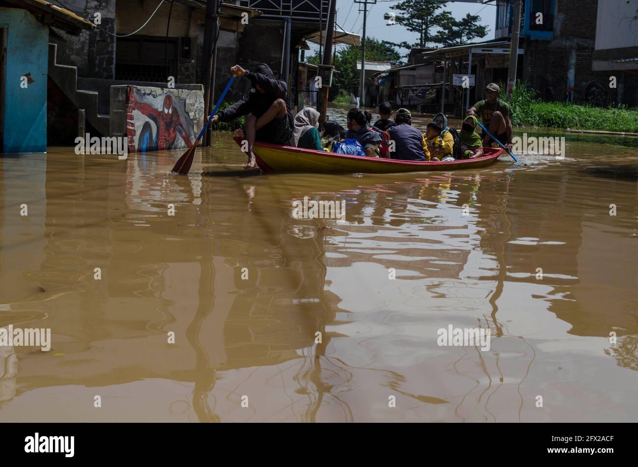 Bandung, Indonesien. Mai 2021. Am 25. Mai 2021 fahren Menschen auf einer überfluteten Straße mit dem Boot, weil der Citarum-Fluss in Bandung, West-Java, Indonesien, überschwemmt wurde. Quelle: Septianjar/Xinhua/Alamy Live News Stockfoto