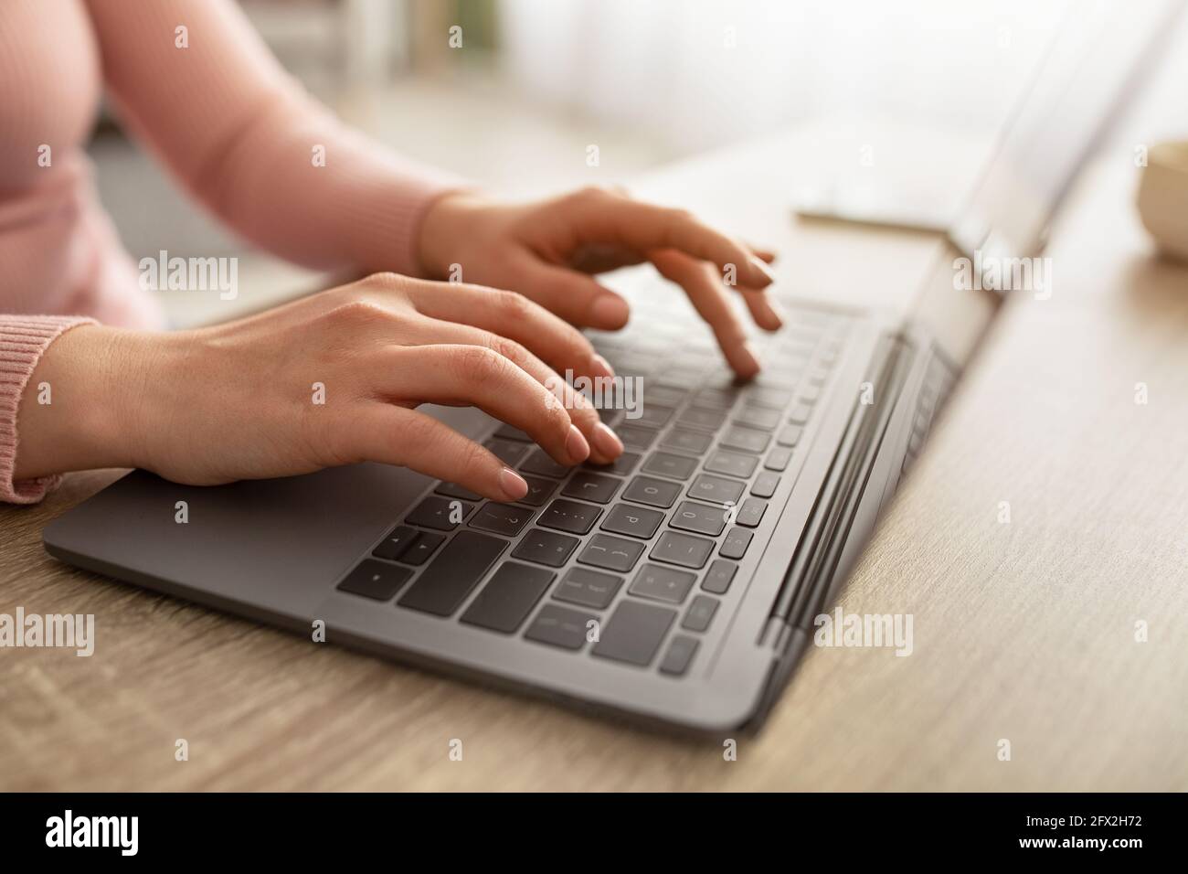 Weibliche Hände tippen auf der Laptop-Tastatur, surfen im Internet oder arbeiten von zu Hause aus während der covid-19 Pandemie. Stockfoto