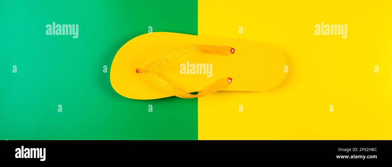 Gelber Gummi-Flip-Flop auf gelbgrünem Hintergrund, Banner Stockfoto