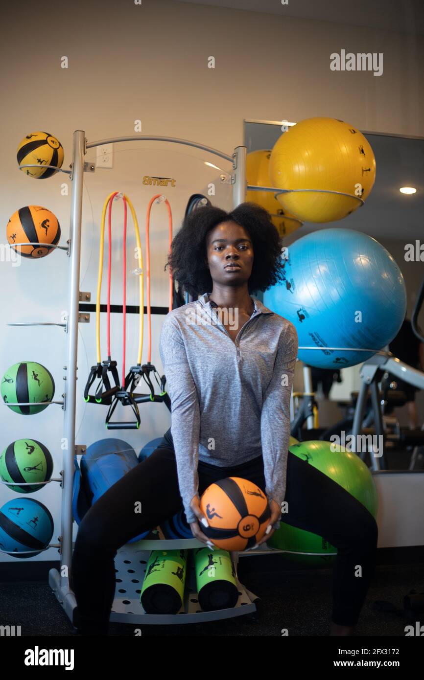Junge athletische Frau, die im Fitnessstudio mit Fitnessball trainiert, eine Person, afroamerikanerin, Nahaufnahme, schwarzes Model, Porträt der sportlichen schwarzen Frau, Stockfoto