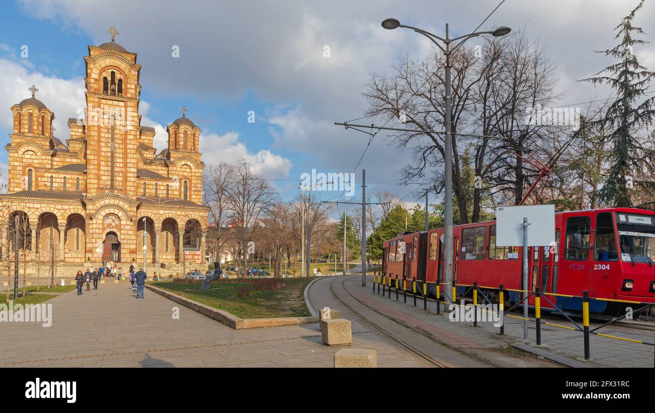 Belgrad, Serbien - 14. Februar 2021: St. Marks Orthodoxe Kirche und Rote Straßenbahn am Bahnhof Tasmajdan Stockfoto
