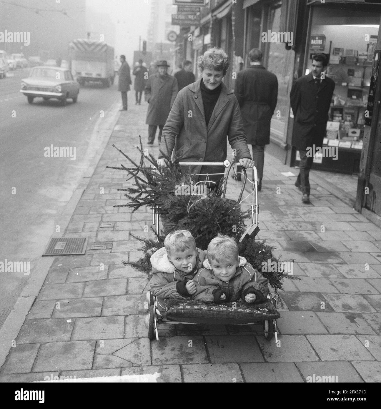 Frau mit Zwillingen im Kinderwagen und auf dem Weihnachtsbaum, 11. Dezember 1964, Weihnachtsbäume, Kinderwagen, Zwillinge, Niederlande, Foto der Presseagentur des 20. Jahrhunderts, zu erinnerende Nachrichten, Dokumentarfilm, historische Fotografie 1945-1990, visuelle Geschichten, Menschliche Geschichte des zwanzigsten Jahrhunderts, Momente in der Zeit festzuhalten Stockfoto