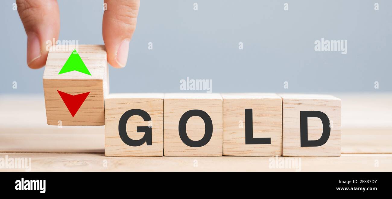 Business man Hand ändern Holz Würfel Block mit GOLD Text auf PFEIL NACH OBEN und unten Symbol Symbol. Zinssatz, Aktien, Finanz-, Verlustrechnung und wirtschaftliche Konz Stockfoto