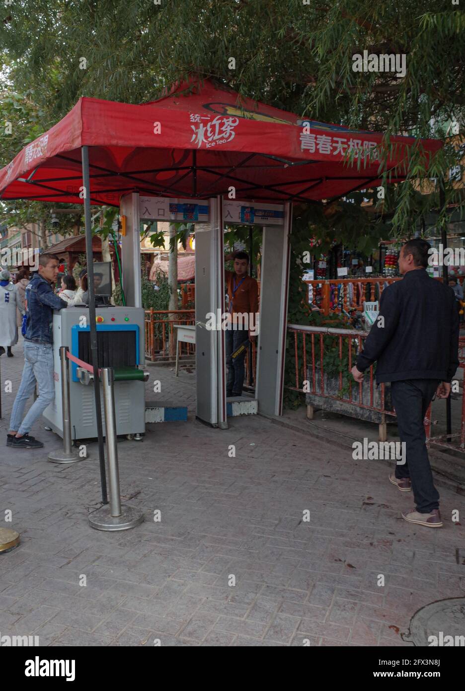 Von hinten gesehen geht der Mann zur Sicherheitszufahrt auf der Ordaishki-Straße. Kashgar. Volksrepublik China Stockfoto