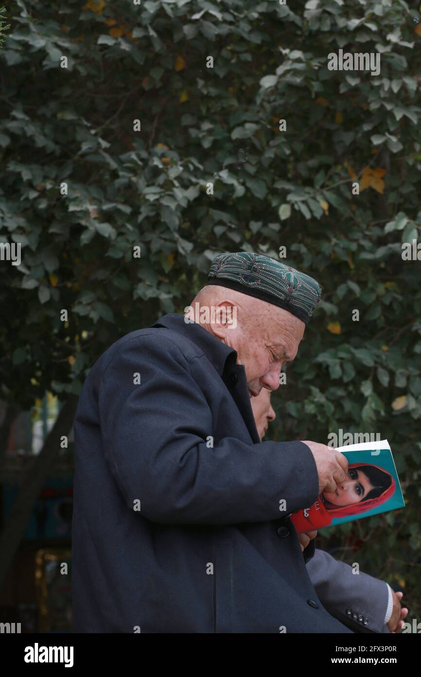 Uigurischer alter Mann liest vor der ID Kah Moschee .Kashgar, Xingiang, China 2019 Stockfoto