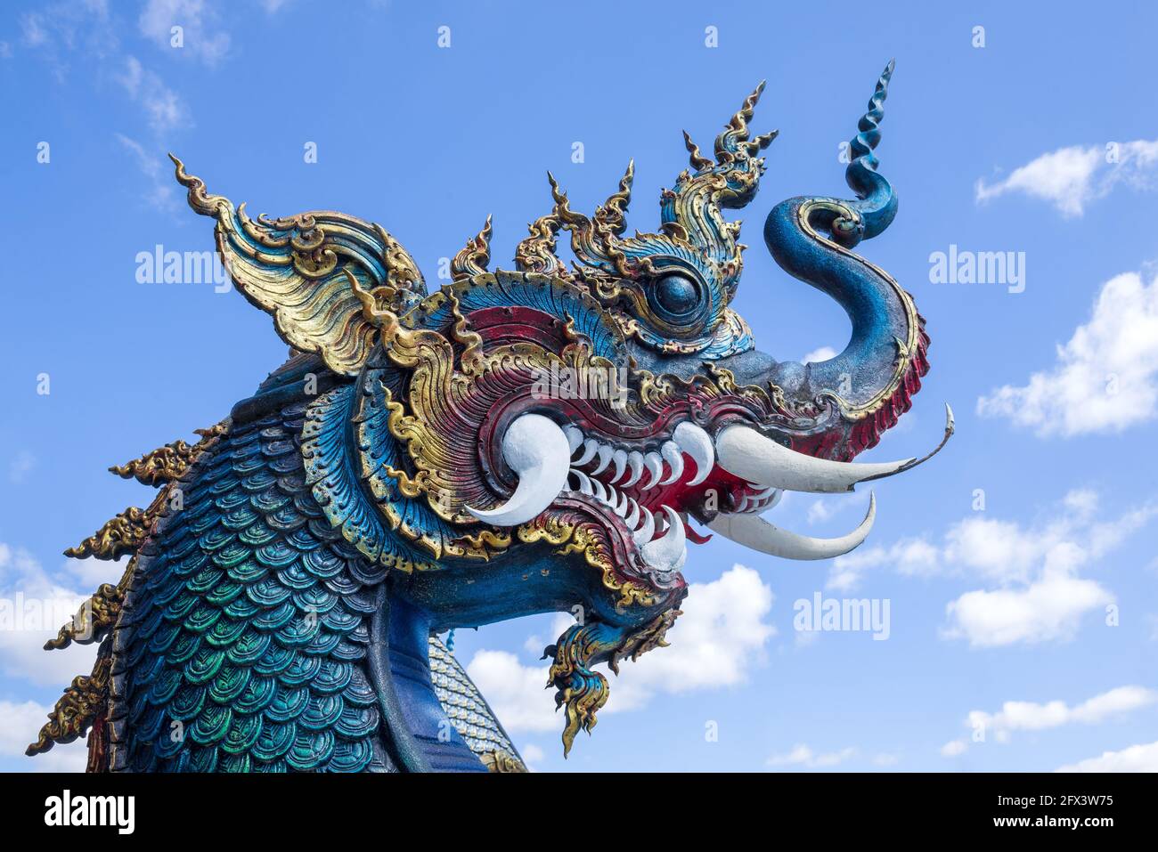 Kopf eines blauen Drachen gegen den Himmel. Buddhistischer Tempel Wat Rong Seur Ten (Blauer Tempel). Chiang Rai, Thailand Stockfoto