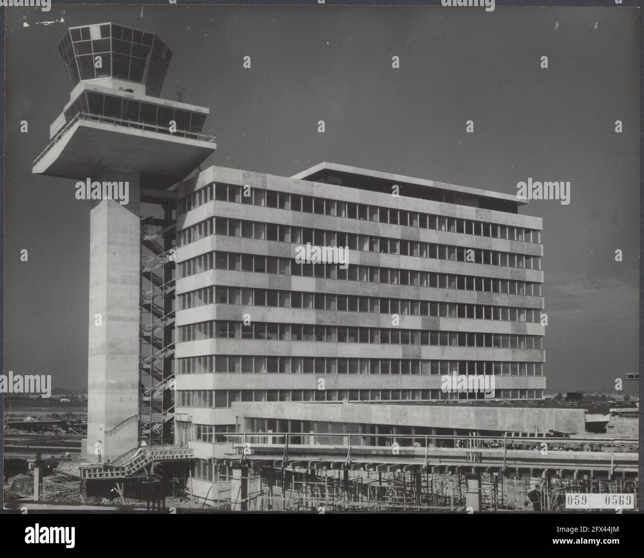 Der Bau der neuen Anbauflache in Schiphol beginnt in die letzte Phase. Bau des 9-stöckigen Bürogebäudes der n.v. Luchthaven Schiphol. An das Bürogebäude angeschlossen ist der 53 Meter hohe Kontrollturm. An der Spitze wird der Beobachtungspol des Meteo mit darüber die Kuppel für die Verkehrskontrolle der National Aviation Administration, 5. Oktober 1965, Bau, Büros, Flughäfen, Niederlande, Foto der Presseagentur des 20. Jahrhunderts, zu erinnerende Nachrichten, Dokumentarfilm, historische Fotografie 1945-1990, visuelle Geschichten, Menschliche Geschichte des zwanzigsten Jahrhunderts, Momente einfangen in Stockfoto