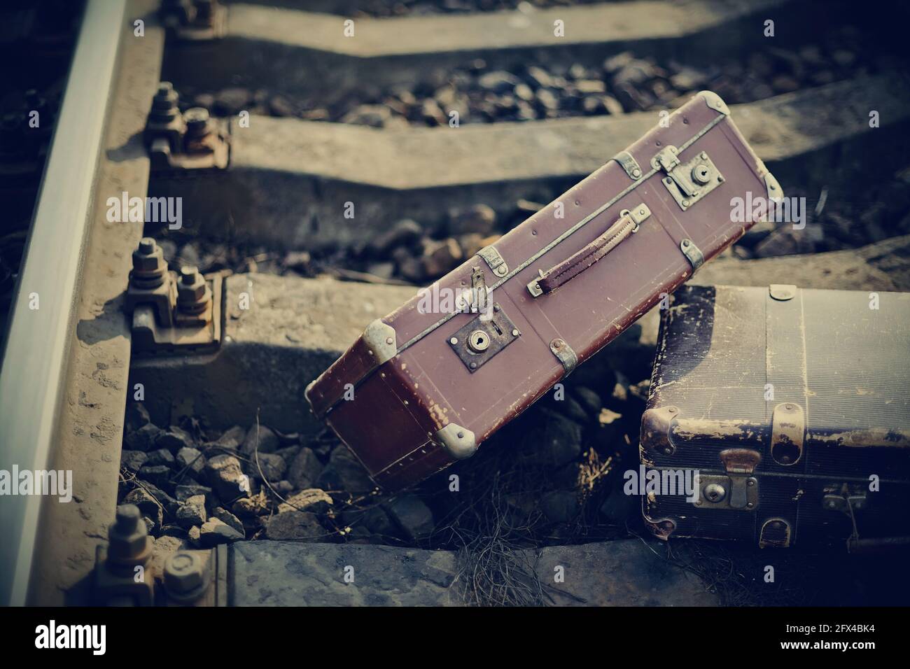 Die alten, vergessenen Vintage-Koffer liegen auf Eisenbahnschienen. Stockfoto