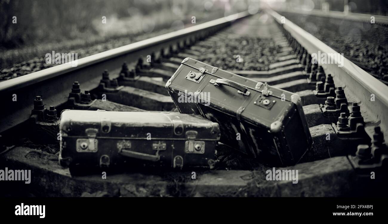 Das Schwarz-Weiß-Bild von zwei alten Koffern auf Schienen. Stockfoto