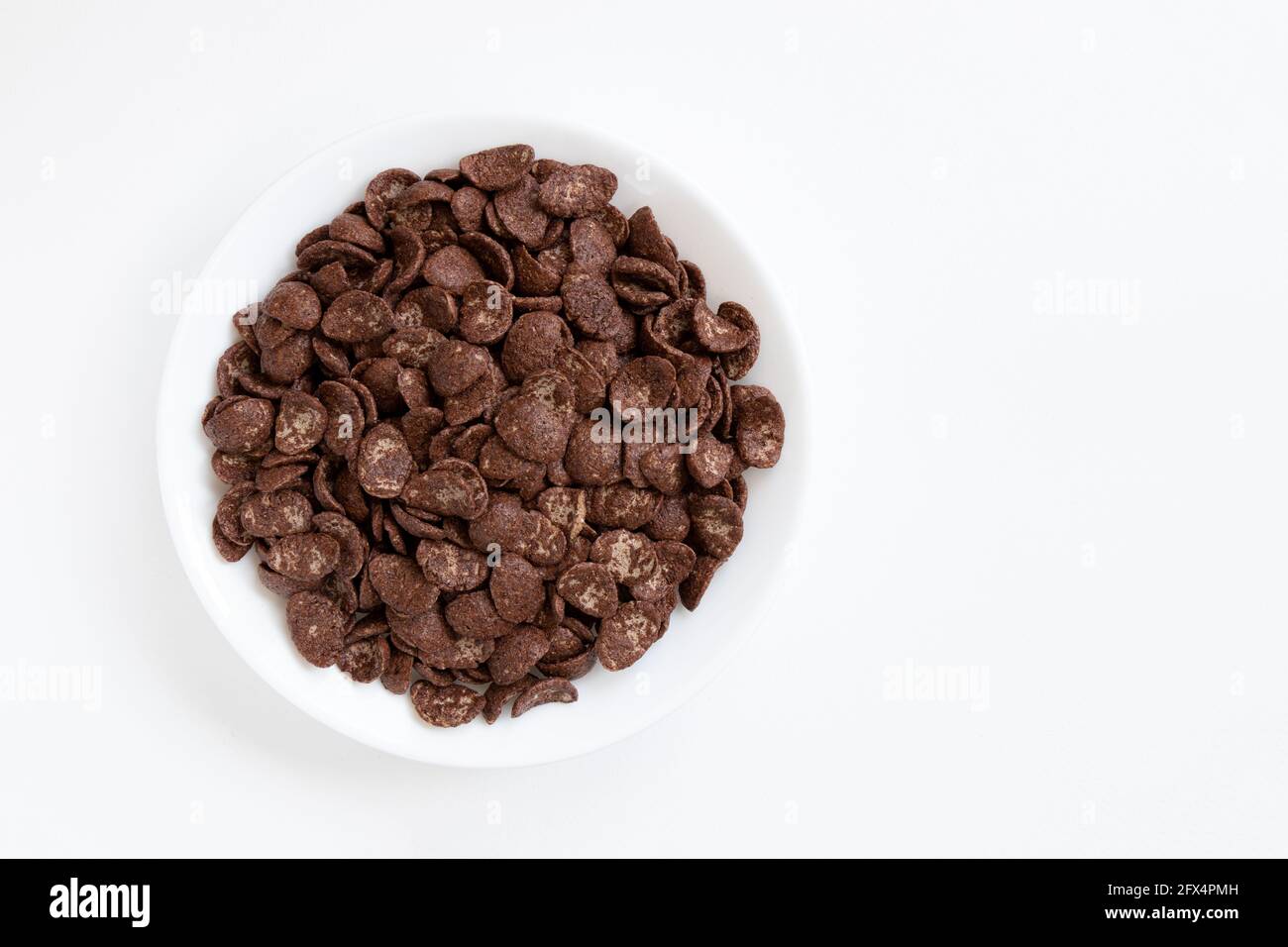 Schokoladenflocken in Schale isoliert auf weißem Hintergrund, gesundes Frühstückskonzept, Teller Cornflakes Stockfoto