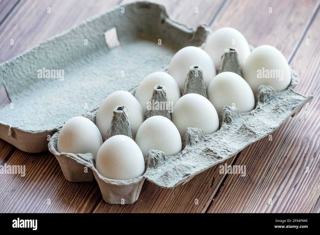 Ein Eierkarton aus Pappe mit zehn weißen Eiern auf einem Holztisch. Eier in  einer Schachtel Stockfotografie - Alamy
