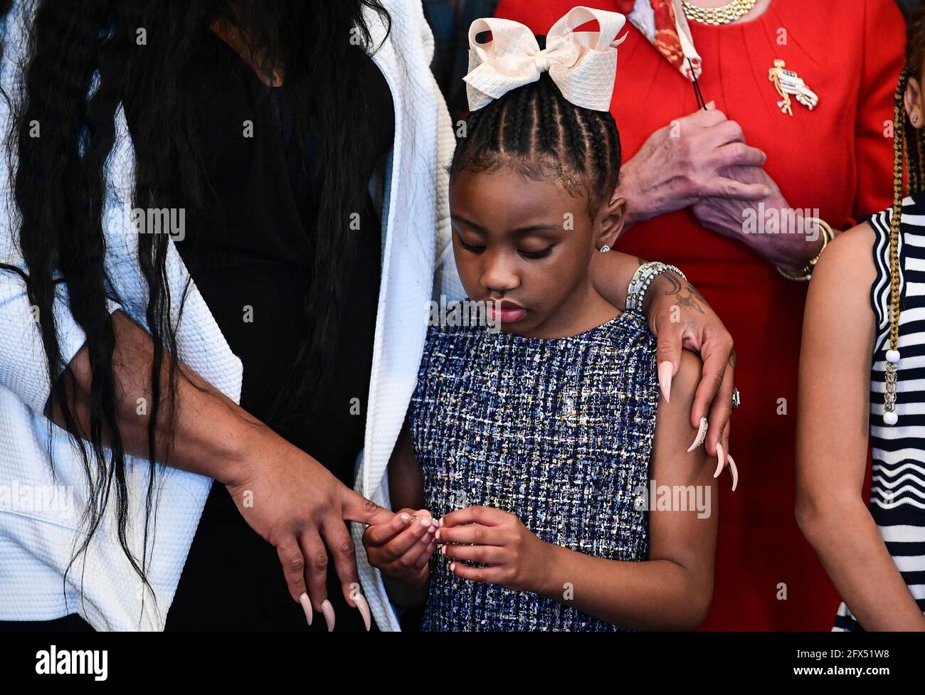 Gianna Floyd, die Tochter von George Floyd, hält die Hand ihrer Mutter Roxie Washington, während sie mit Mitgliedern der Familie Floyd vor einem Treffen zum Gedenken an den Tod von George Floyd mit der Sprecherin des Repräsentantenhauses der Vereinigten Staaten, Nancy Pelosi (Demokratin von Kalifornien), zusammensteht. Am US-Kapitol in Washington, USA, 25. Mai 2021. Quelle: Erin Scott/Pool via CNP /MediaPunch Stockfoto