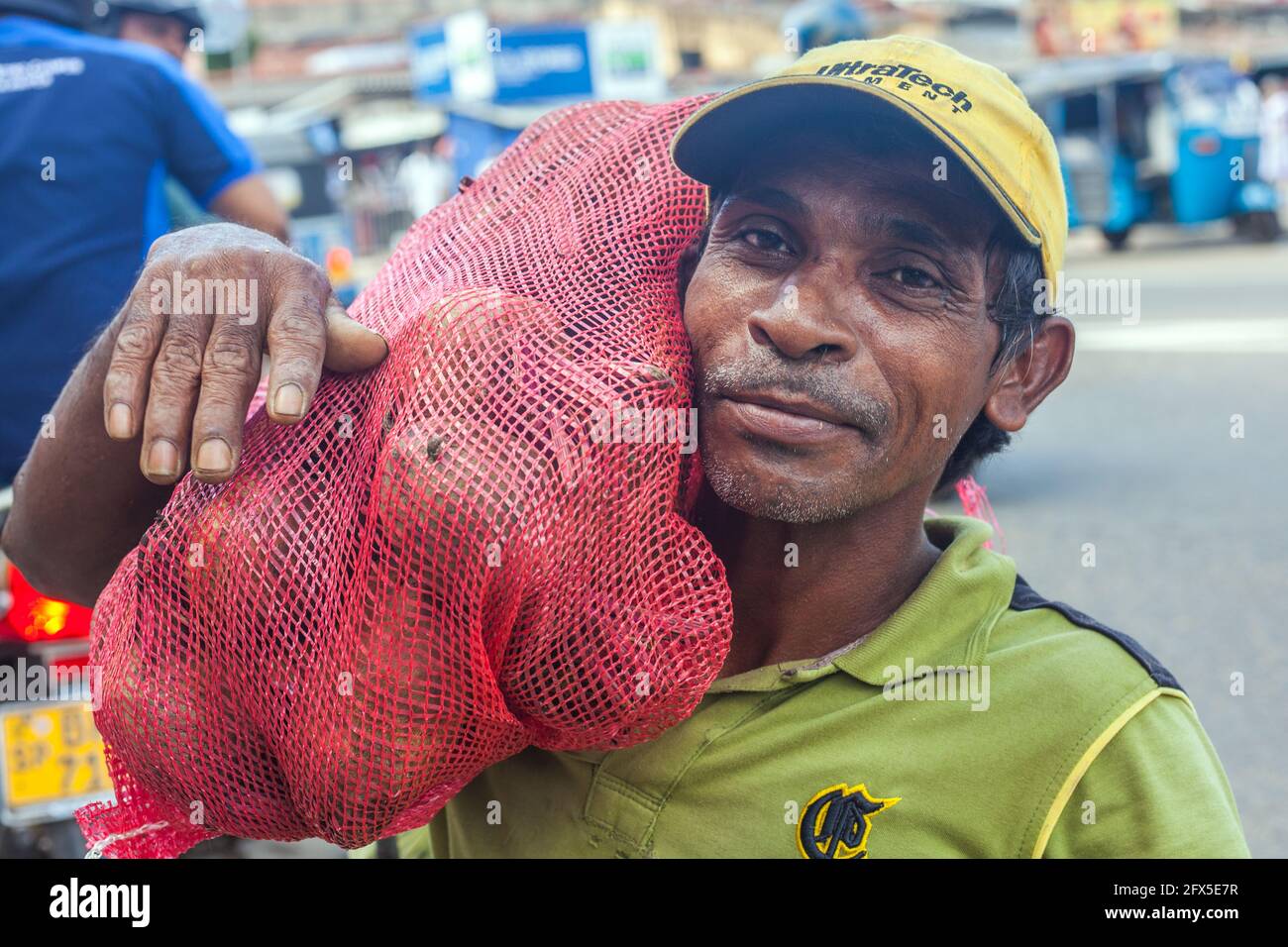 Srilankischer Straßenportier, der Last auf der Schulter trägt, in strret, Tangalle, Sri Lanka Stockfoto