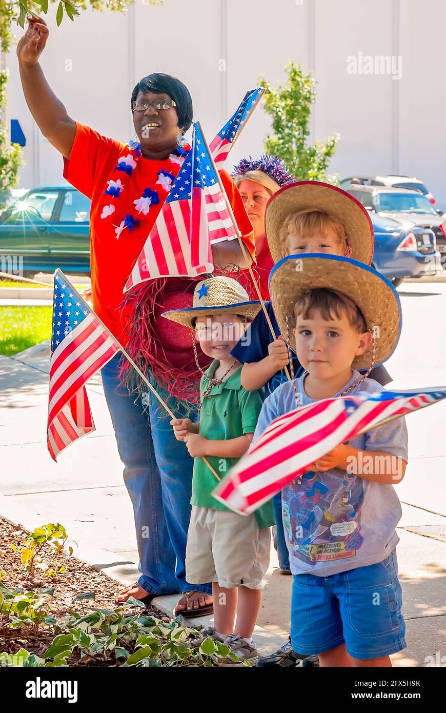 Kinder und Erwachsene winken am 30. Juni 2011 in Columbus, Mississippi, amerikanische Flaggen. Die Gruppe veranstaltete eine informelle Parade am 4. Juli. Stockfoto