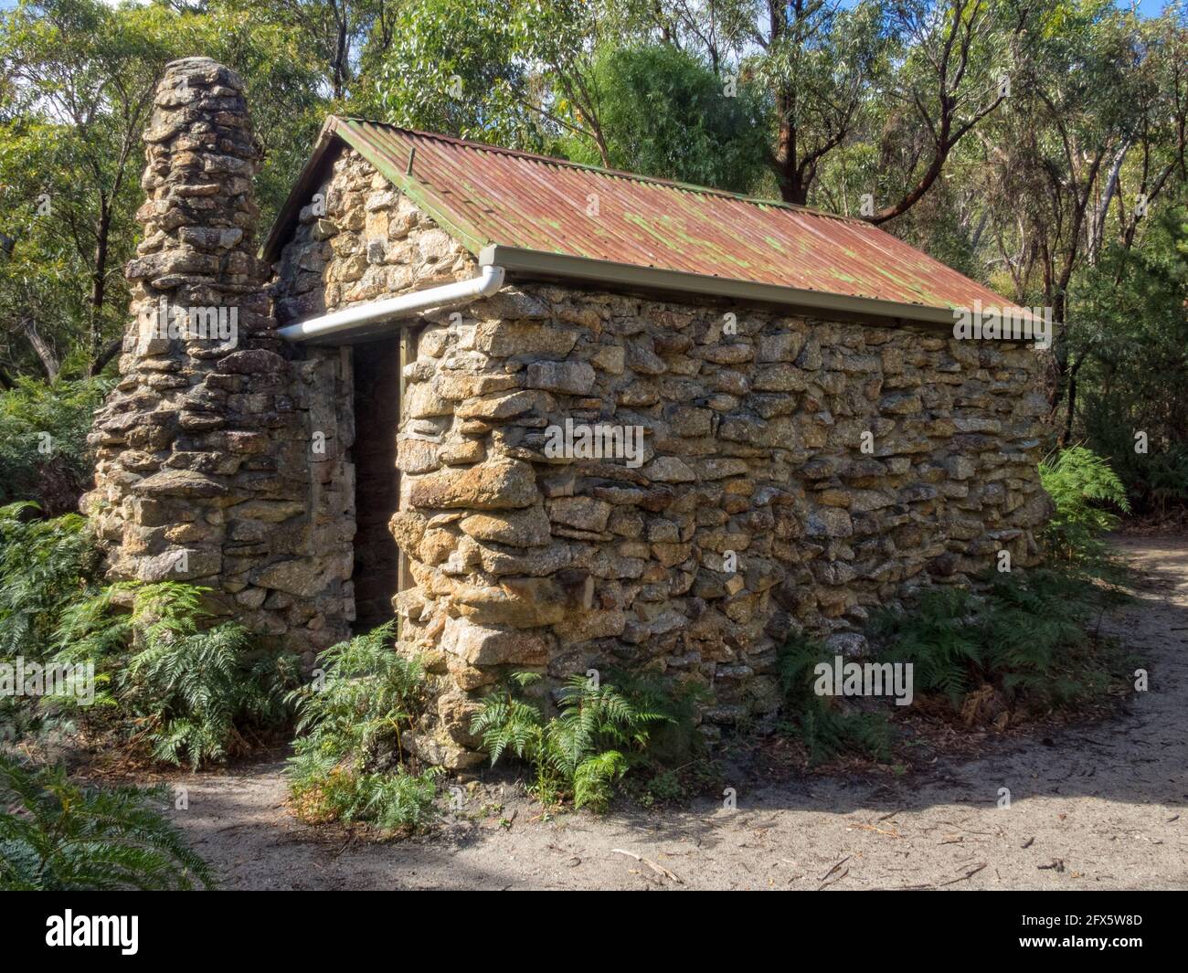 Halfway Hut entlang des Telegraph Track ist eine steinerne Buschhütte, umgeben von üppiger Küstenvegetation - Wilsons Promontory, Victoria, Australien Stockfoto