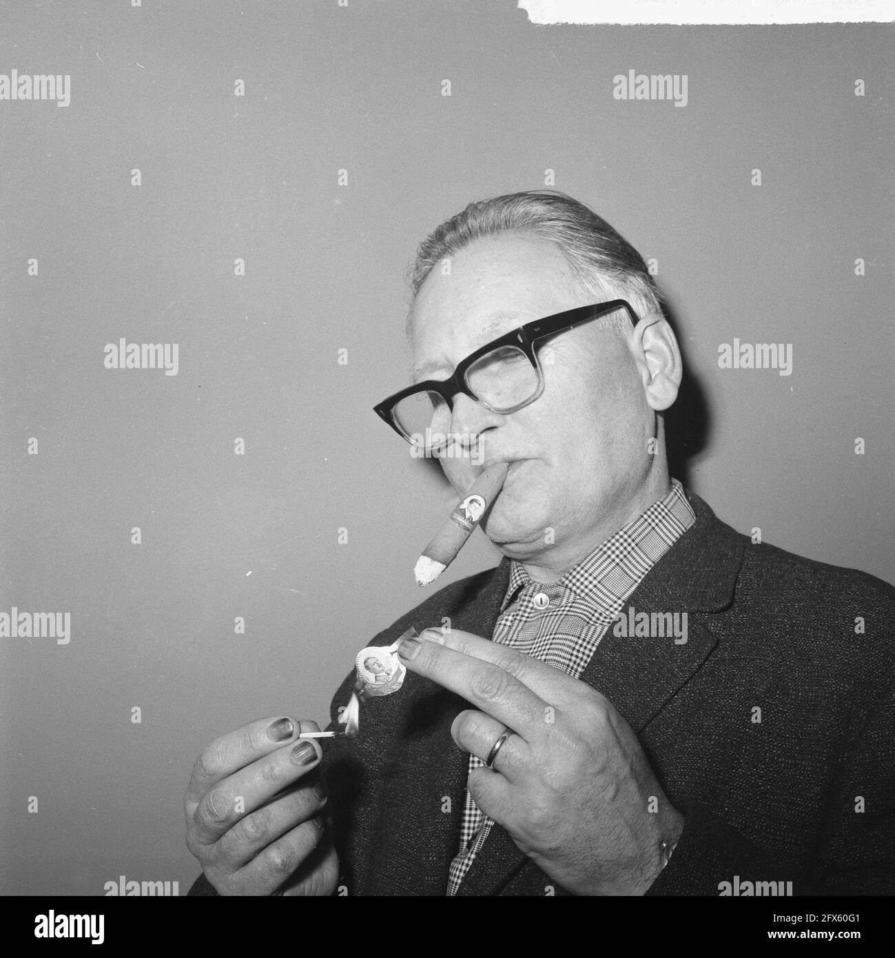 Große Männer und Tyrannen, Zigarrenbands, Mann zündet sich mit Hitler-Porträt an, 2. Dezember 1964, Rauchen, Zigarren, Zigarrenbands, Niederlande, Foto der Presseagentur des 20. Jahrhunderts, zu erinnerende Nachrichten, Dokumentarfilm, historische Fotografie 1945-1990, visuelle Geschichten, Menschliche Geschichte des zwanzigsten Jahrhunderts, Momente in der Zeit festzuhalten Stockfoto