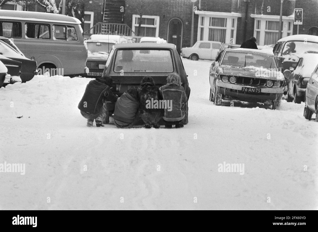 Großer Schneefall macht Verkehr unmöglich oder kaum möglich; gleitende Jungen hinter dem Auto, 14. Februar 1979, VERKEHR, Schnee, Niederlande, Presseagentur des 20. Jahrhunderts, Foto, Nachrichten zum erinnern, Dokumentarfilm, historische Fotografie 1945-1990, visuelle Geschichten, Menschliche Geschichte des zwanzigsten Jahrhunderts, Momente in der Zeit festzuhalten Stockfoto