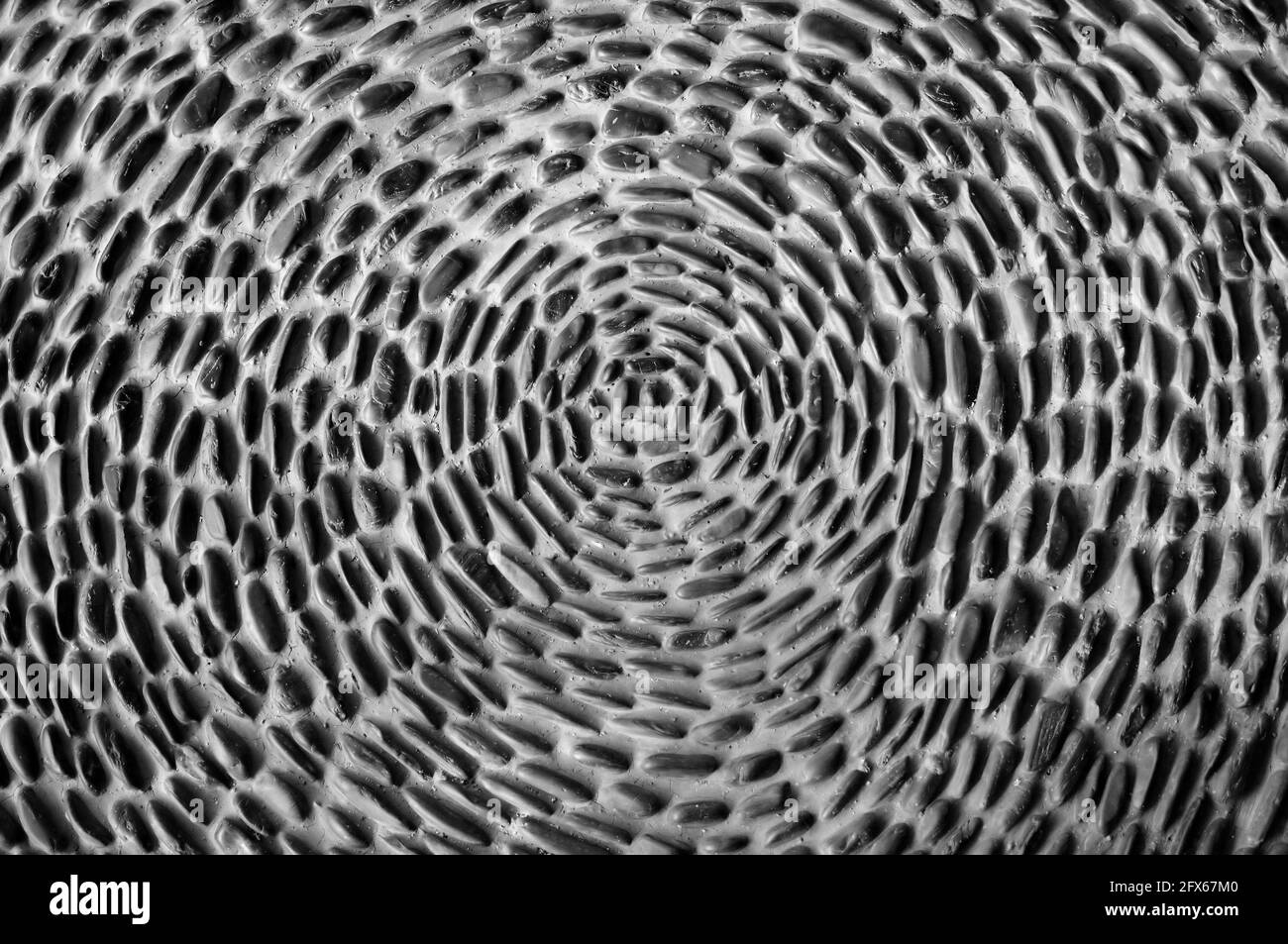 Kieselsteine in einem radialen Muster zementiert Stockfoto