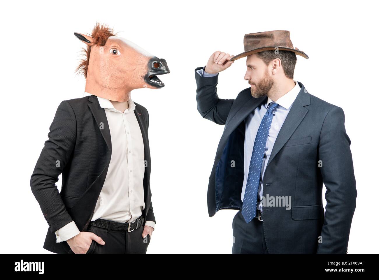 Cowboy Mann und Geschäftsmann in Pferdekopfmaske auf Kostümfest, Corporate Halloween Stockfoto