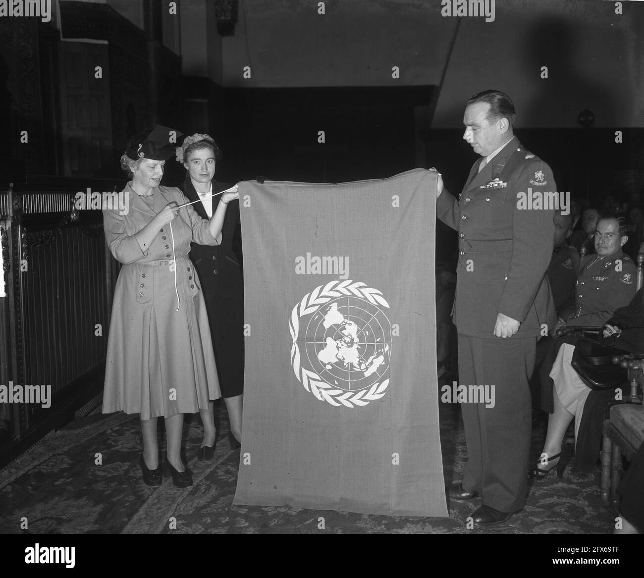 Gedenken an den Tag der Vereinten Nationen im Ridderzaal, Den Haag. Im Namen des niederländischen Verbands der Vereinten Nationen wurde dem Kommandanten der Korea-Abteilung, Major M.P.A. den Ouden, eine UN-Flagge überreicht. Fltr. dr. Lunsingh Meyer, frau B.J.A. de Kanter-van Hettinga Tromp, Major Den Ouden und der stellvertretende Kommandeur Kapitän Eekhout, 23. Oktober 1950, gedenkfeiern, internationale Organisationen, Militär, Offiziere, Verbände, Flaggen, Niederlande, 20. Jahrhundert Presseagentur Foto, Nachrichten zu erinnern, Dokumentarfilm, historische Fotografie 1945-1990, visuelle Geschichten, Menschliche Geschichte der Stockfoto