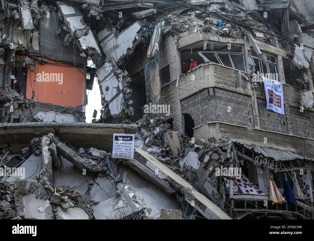 Gaza, Palästina. Mai 2021. Palästinenser, die nach dem Waffenstillstand zwischen Israel und den Aktivisten des Gazastreifens in Gaza-Stadt unter zerstörten Häusern zu sehen sind. DER US-Spitzendiplomat Antony Blinken schwor Unterstützung beim Wiederaufbau des zerrütteten Gazastreifens und bei der Unterstützung eines Waffenstillstands zwischen der Hamas und Israel, bestand aber darauf, dass die militanten islamistischen Herrscher des Territoriums von keiner Hilfe profitieren würden. Kredit: SOPA Images Limited/Alamy Live Nachrichten Stockfoto