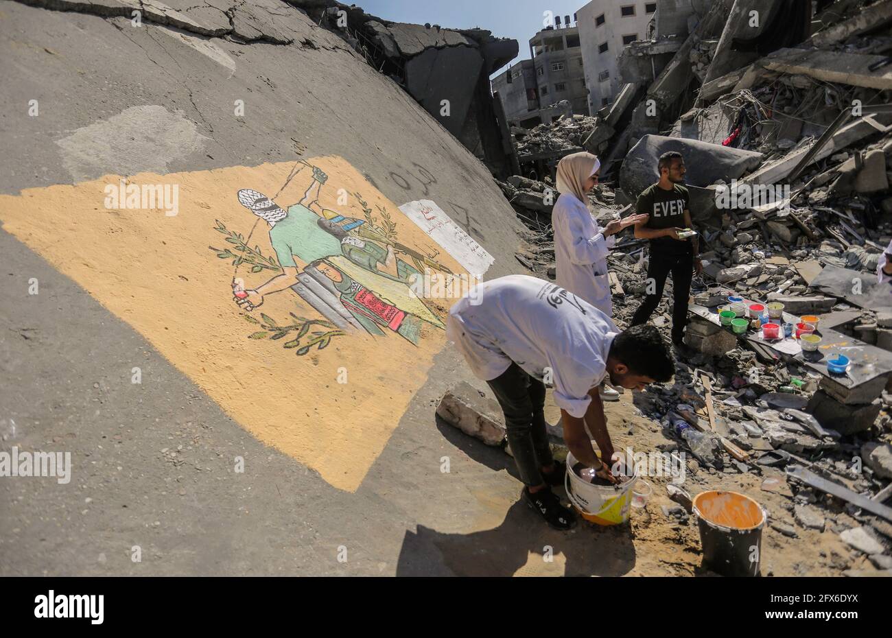 Gaza, Palästina. Mai 2021. Palästinensische Künstler malen Wandmalereien auf eingestürzte Gebäude nach den israelischen Streiks in Gaza. DER US-Spitzendiplomat Antony Blinken schwor Unterstützung beim Wiederaufbau des zerrütteten Gazastreifens und bei der Unterstützung eines Waffenstillstands zwischen der Hamas und Israel, bestand aber darauf, dass die militanten islamistischen Herrscher des Territoriums von keiner Hilfe profitieren würden. (Foto von Mahmoud Issa/SOPA Images/Sipa USA) Quelle: SIPA USA/Alamy Live News Stockfoto