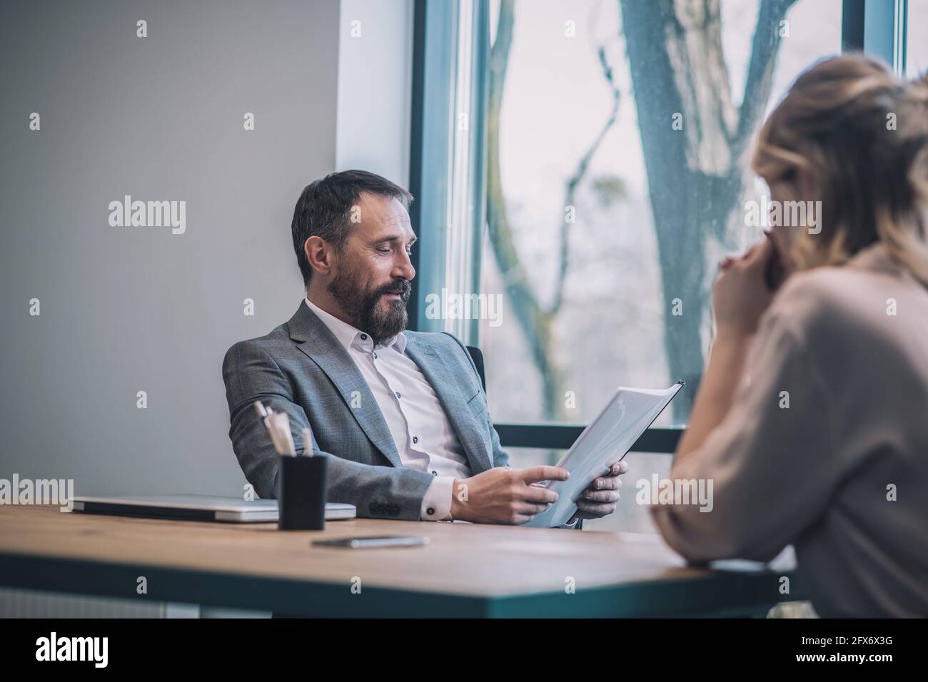 Aufmerksamer Chef beim Studieren von Dokumenten und Assistentin. Stockfoto