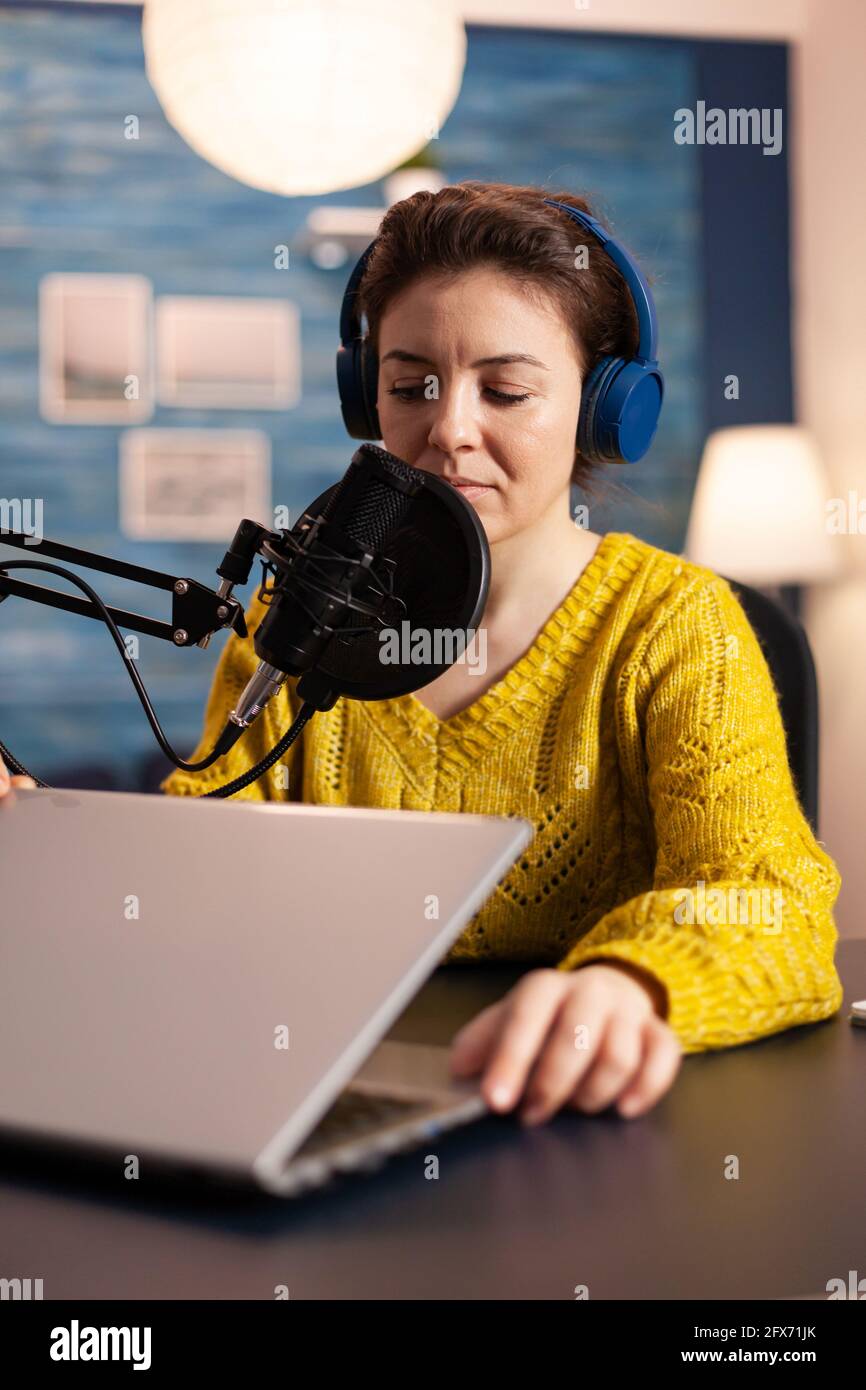 Blogger, der den Laptop öffnet, beginnt mit Followern zu sprechen, die im Heimstudio einen neuen Podcast aufnehmen. On-Air-Online-Produktion Internet Broadcast Show Host Streaming Live-Inhalte, Aufnahme digitaler Video-Vlog. Stockfoto