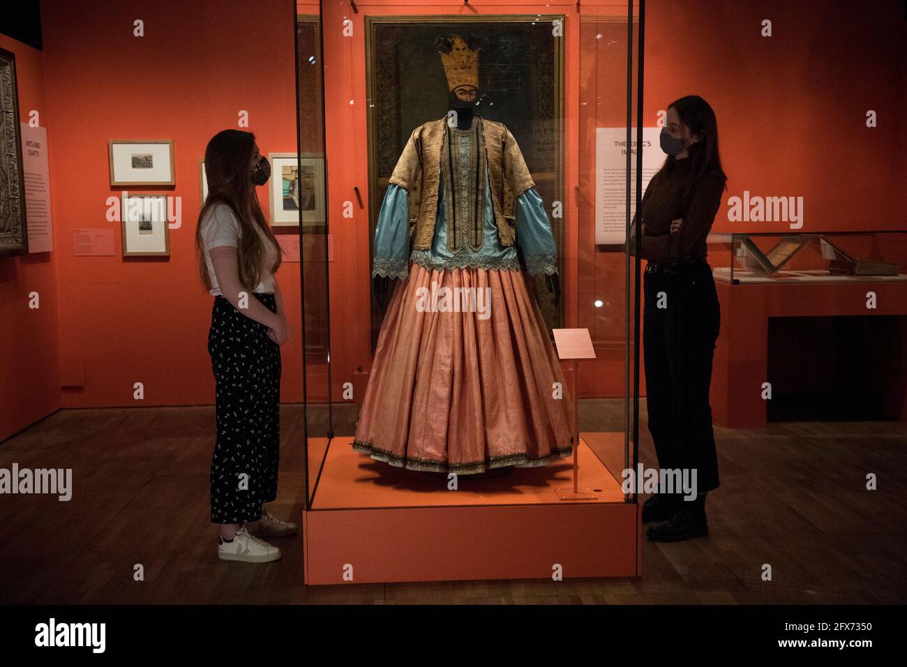 Museumsmitarbeiter sehen sich eine Damenjacke, Bluse und Rock von 1840 bis 50 an, die vor der bevorstehenden Ausstellung „Epic Iran“ im Victoria and Albert Museum in London zu sehen ist. Bilddatum: Dienstag, 25. Mai 2021. Stockfoto