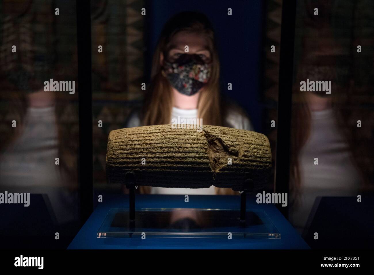 Ein Mitarbeiter des Museums sieht sich den Cyrus Cylinder, 539-538BC, an, der im Vorfeld der bevorstehenden Ausstellung Epic Iran im Victoria and Albert Museum in London ausgestellt wird. Bilddatum: Dienstag, 25. Mai 2021. Stockfoto