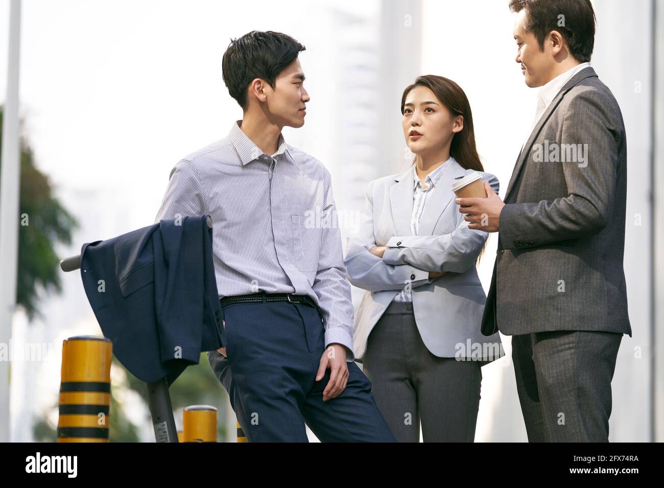 Drei asiatische Geschäftsleute unterhalten sich auf der Straße in der Innenstadt von Moderne Stadt Stockfoto