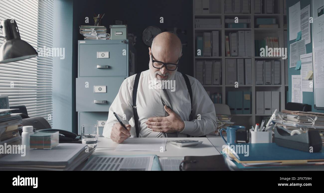 Der Unternehmensleiter überprüft einen Finanzbericht und hat ein Konzept für Magenschmerzen, Stress und Erschöpfung Stockfoto