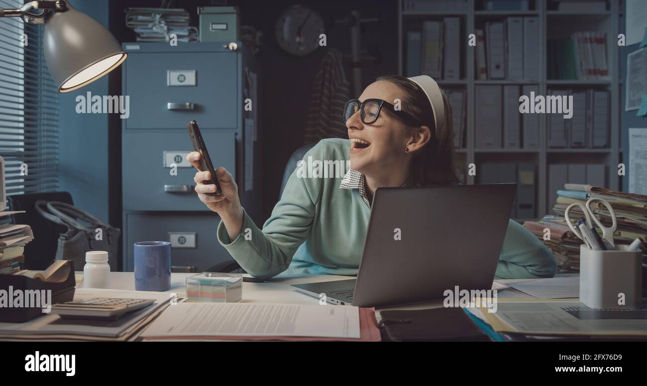 Ineffiziente Videoanrufe von Büromitarbeitern mit ihrem Smartphone statt mit Arbeiten Stockfoto