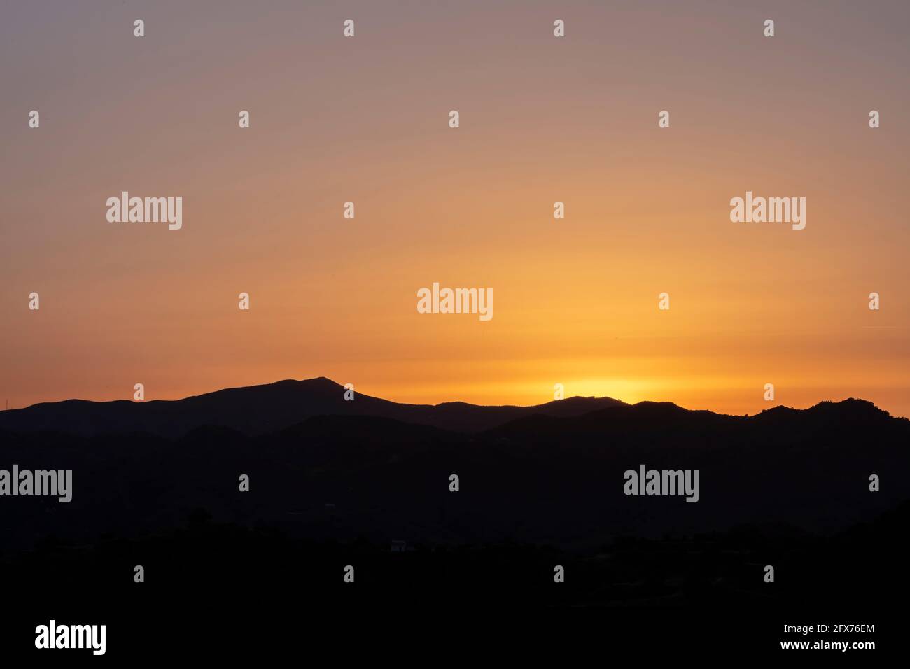 Bergsilhouette bei Sonnenuntergang in der Nähe von Almogia Dorf, Malaga, Spanien Stockfoto