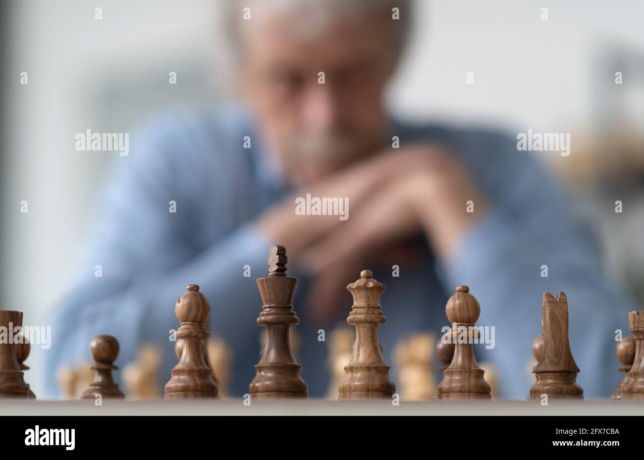 Älterer Mann, der Schach spielt, übt sein Gedächtnis aus Stockfoto