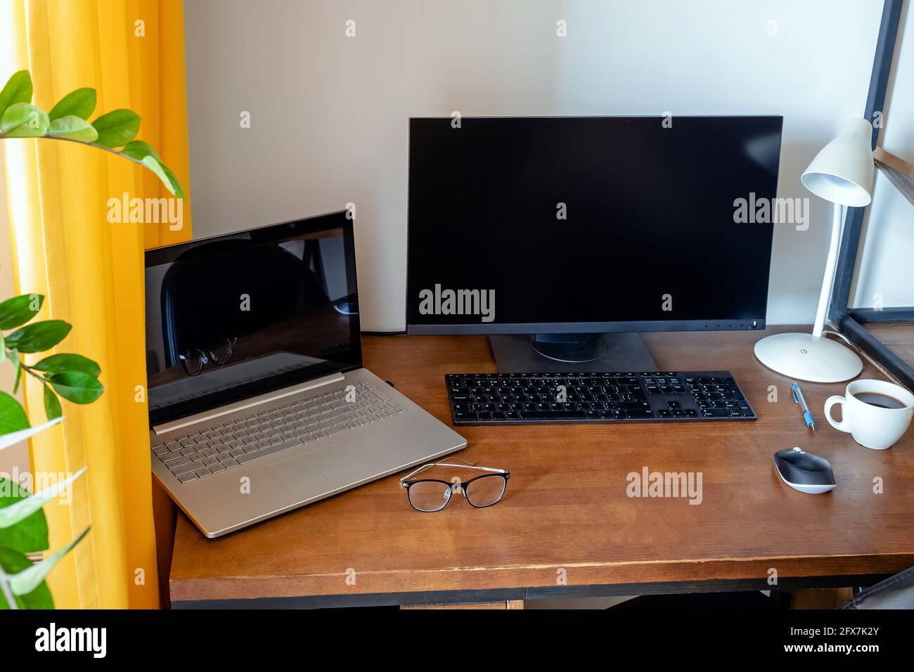 Arbeitsplatz mit Holztisch und grüner Pflanze. Stockfoto