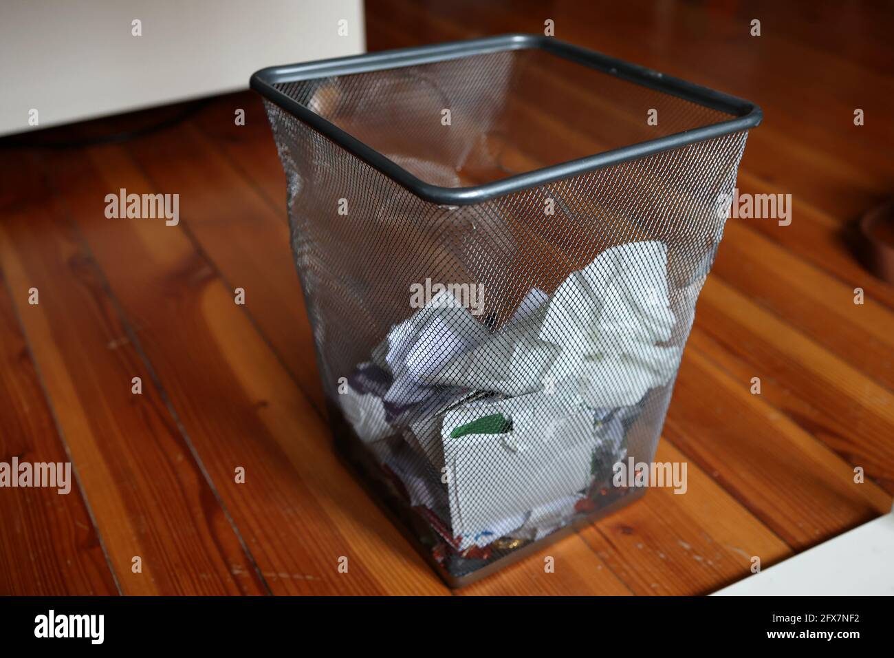 Papierabfallbehälter im Büro unter dem Tisch. Stockfoto