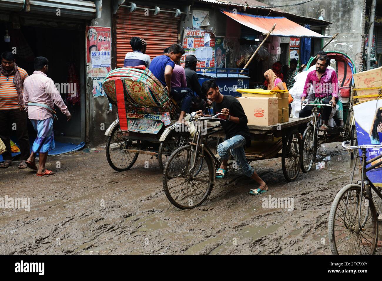Gütertransport über eine schlammige Straße im Chawk Bazar in Dhaka, Bangladesch. Stockfoto