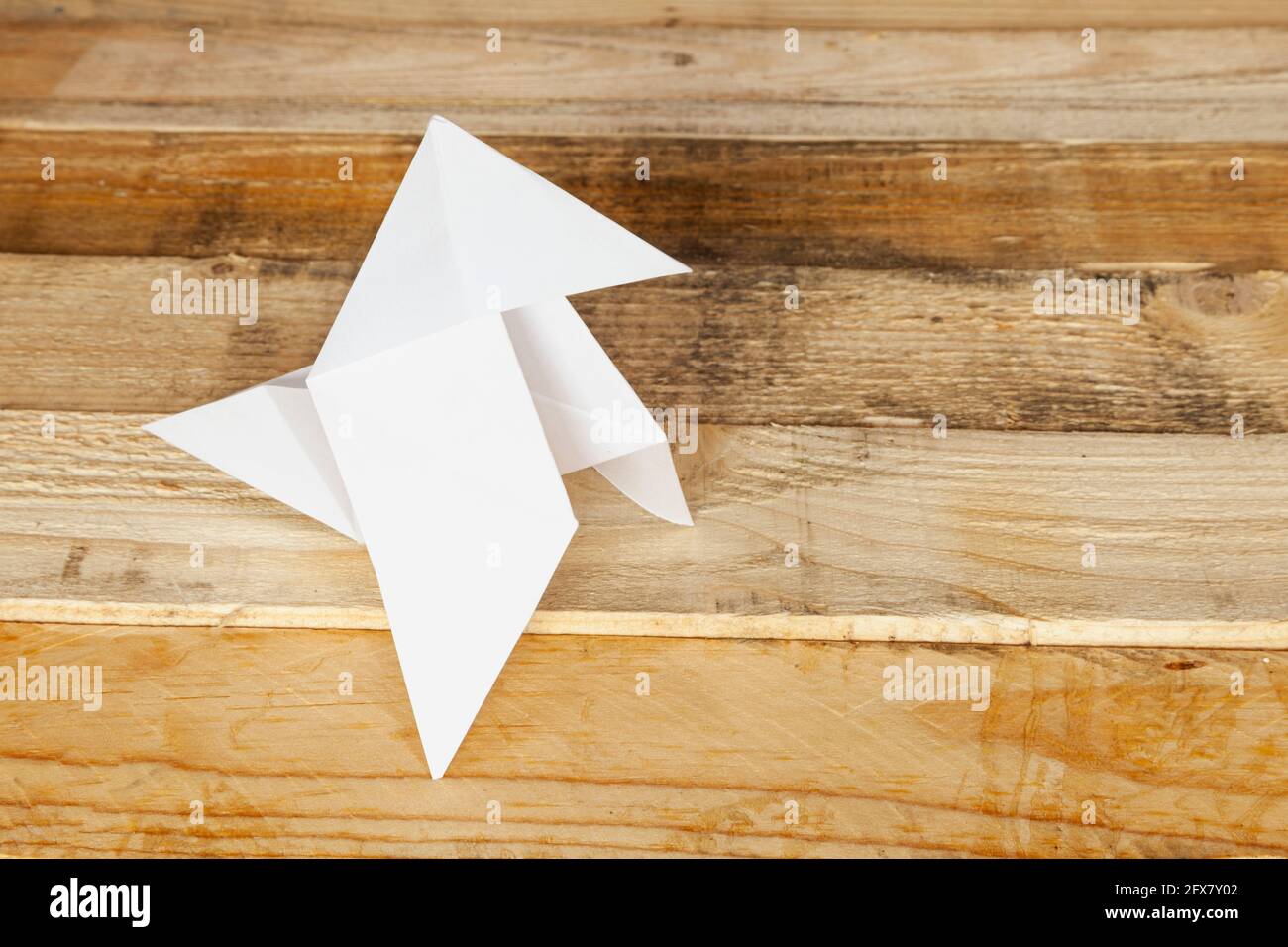 Klassische Origami-Vogel Figur isoliert auf Holzhintergrund. Stockfoto