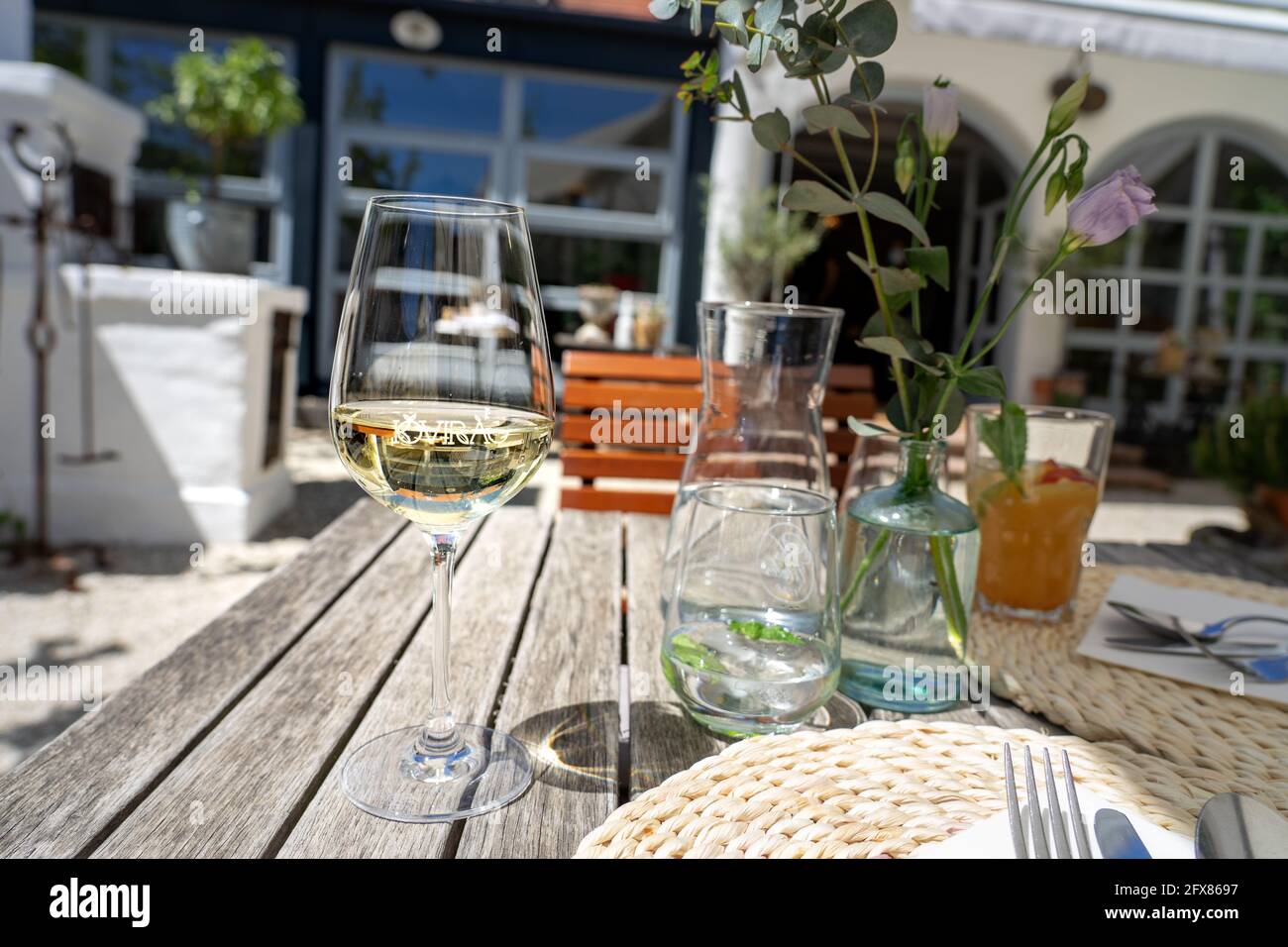 05.15.2021- Koveskal, Ungarn: Vintage Tisch im Garten mit einem Glas Wein im Restaurant Kovirag im Kali-Becken Stockfoto