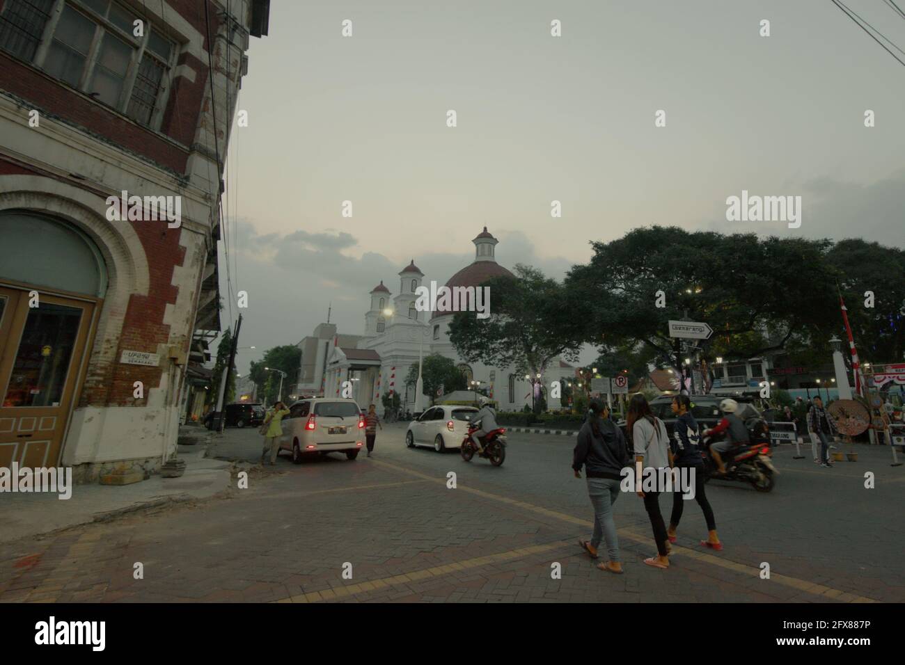 Junge Frauen, die eine Straße entlang in der Altstadt von Semarang City gehen, die im Volksmund als „Kota Lama“ (Altstadt) bekannt ist, ein kulturelles Erbe, das teilweise während der Kolonialzeit entwickelt wurde. Semarang, Zentraljava, Indonesien. Stockfoto