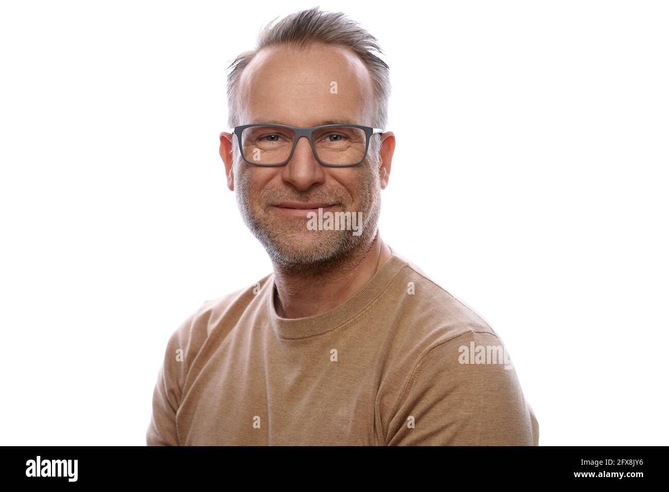Lächelnder, freundlicher, unrasiert gealterter Mann in Freizeitkleidung mit einer drehenden Brille Um die Kamera im Oberkörper-Portrait zu betrachten Auf Weiß Stockfoto