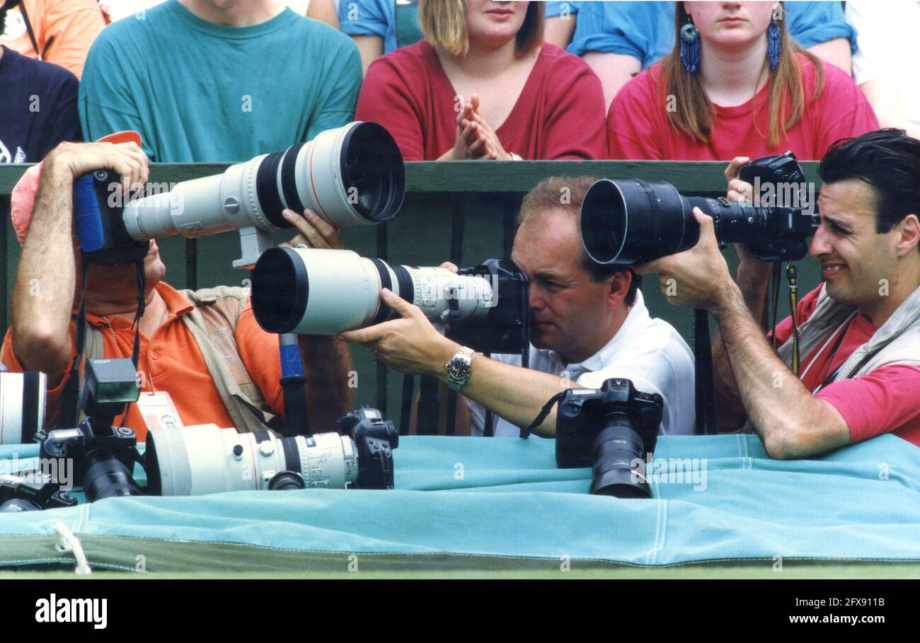 Professionelle Fotografen arbeiten auf Center Court bei Wimbledon Tennis Tournament 1990er Jahre. Sportfotografen Fotografie eng Squeeze überfüllt Großbritannien Stockfoto