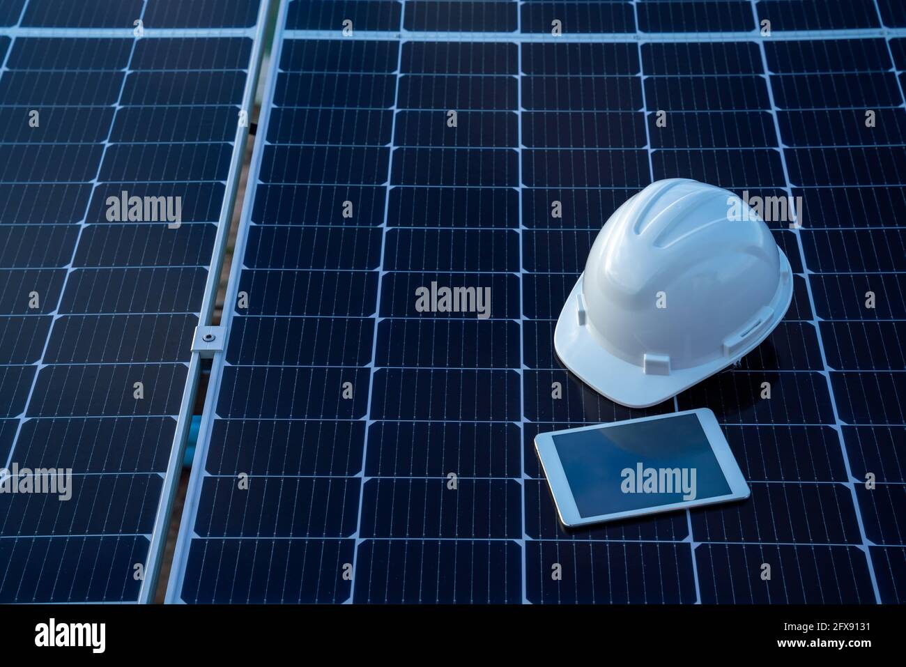 Draufsicht des Helms mit Tablet auf dem Solarpanel für die Arbeit Solarstation Photovoltaik-Panels, Wissenschaft Solarenergie, Ingenieur arbeiten an der Überprüfung und Stockfoto